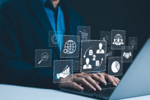 Business hands on keyboard with floating tech icons representing integrated AI.